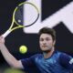 Miomir Kecmanovic of Serbia plays a forehand return to Carlos Alcaraz of Spain during their fourth round match at the Australian Open tennis championships at Melbourne Park, Melbourne, Australia, Monday, Jan. 22, 2024. (AP Photo/Andy Wong)