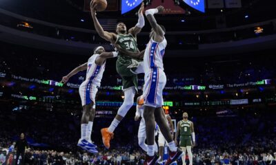 Milwaukee Bucks' Giannis Antetokounmpo (34) goes up for a shot against Philadelphia 76ers' Buddy Hield, left, and Paul Reed during the second half of an NBA basketball game, Sunday, Feb. 25, 2024, in Philadelphia. (AP Photo/Matt Rourke)