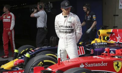FILE - Mercedes driver Lewis Hamilton of Britain looks at Finnish driver Kimi Raikkonen's Ferrari after getting pole in the qualifying session for the Chinese Formula One Grand Prix at Shanghai International Circuit in Shanghai, China, Saturday, April 11, 2015. Seven-time Formula One champion Lewis Hamilton has been linked with a shock move from Mercedes to Ferrari next year. (AP Photo/Toru Takahashi, File)