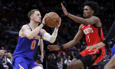 New York Knicks guard Donte DiVincenzo (0) looks to shoot while under pressure from Houston Rockets forward Amen Thompson (1) during the first half of an NBA basketball game Monday, Feb. 12, 2024, in Houston. (AP Photo/Michael Wyke)