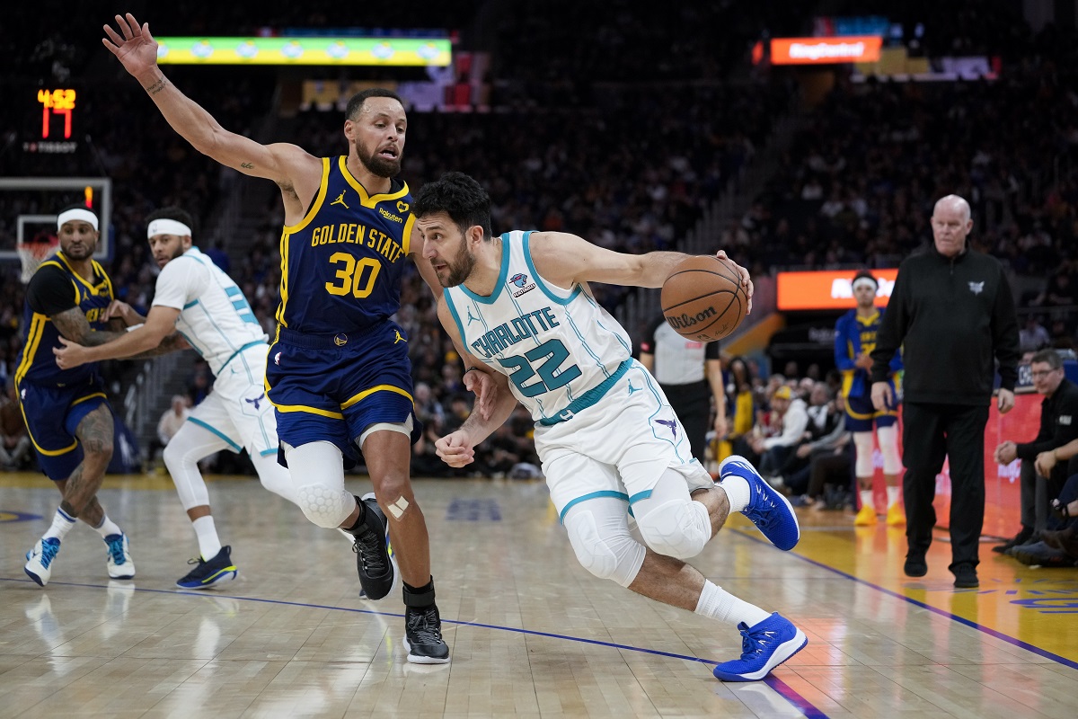 Charlotte Hornets guard Vasilije Micic (22) tries to get around Golden State Warriors guard Stephen Curry (30) during the second half of an NBA basketball game, Friday, Feb. 23, 2024, in San Francisco. (AP Photo/Godofredo A. Vásquez)