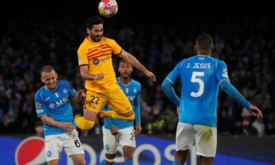 Barcelona's Ilkay Gundogan heads the ball besides Napoli's Mario Rui during the Champions League, round of 16, first leg soccer match between SSC Napoli and FC Barcelona at the Diego Maradona stadium in Naples, Italy, Wednesday, Feb. 21, 2024. (AP Photo/Gregorio Borgia)