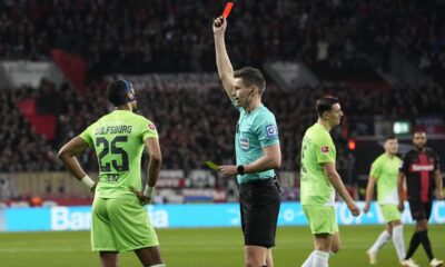 Referee Daniel Siebert shows the red card to Wolfsburg's Moritz Jenz, left, during the German Bundesliga soccer match between Bayer Leverkusen and VfL Wolfsburg at the BayArena in Leverkusen, Germany, Sunday, March 10, 2024. (AP Photo/Martin Meissner)