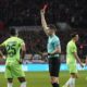 Referee Daniel Siebert shows the red card to Wolfsburg's Moritz Jenz, left, during the German Bundesliga soccer match between Bayer Leverkusen and VfL Wolfsburg at the BayArena in Leverkusen, Germany, Sunday, March 10, 2024. (AP Photo/Martin Meissner)