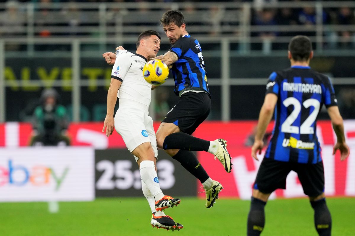 Napoli's Giacomo Raspadori, left, jumps for the ball with Inter Milan's Francesco Acerbi during the Serie A soccer match between Inter Milan and Napoli at the San Siro Stadium, in Milan, Italy, Sunday, March 17, 2024. (AP Photo/Antonio Calanni)