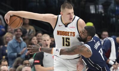 Denver Nuggets center Nikola Jokic (15) keeps the ball out of reach against Dallas Mavericks guard Kyrie Irving (11) during the first half of an NBA basketball game in Dallas, Sunday, March 17, 2024. (AP Photo/LM Otero)