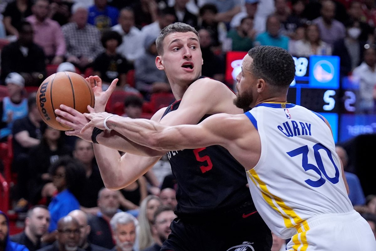 Miami Heat forward Nikola Jovic (5) looks for an opening past Golden State Warriors guard Stephen Curry (30) during the first half of an NBA basketball game, Tuesday, March 26, 2024, in Miami. (AP Photo/Wilfredo Lee)