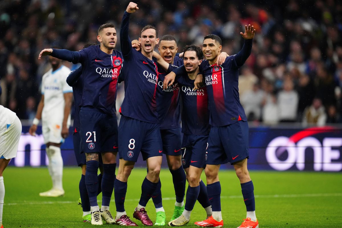 PSG's Vitinha, second from right, celebrates with teammate after he scored his side's first goal during the French League One soccer match between Marseille and Paris at the Velodrome stadium in Marseille, south of France, Sunday, March 31, 2024. (AP Photo/Daniel Cole)