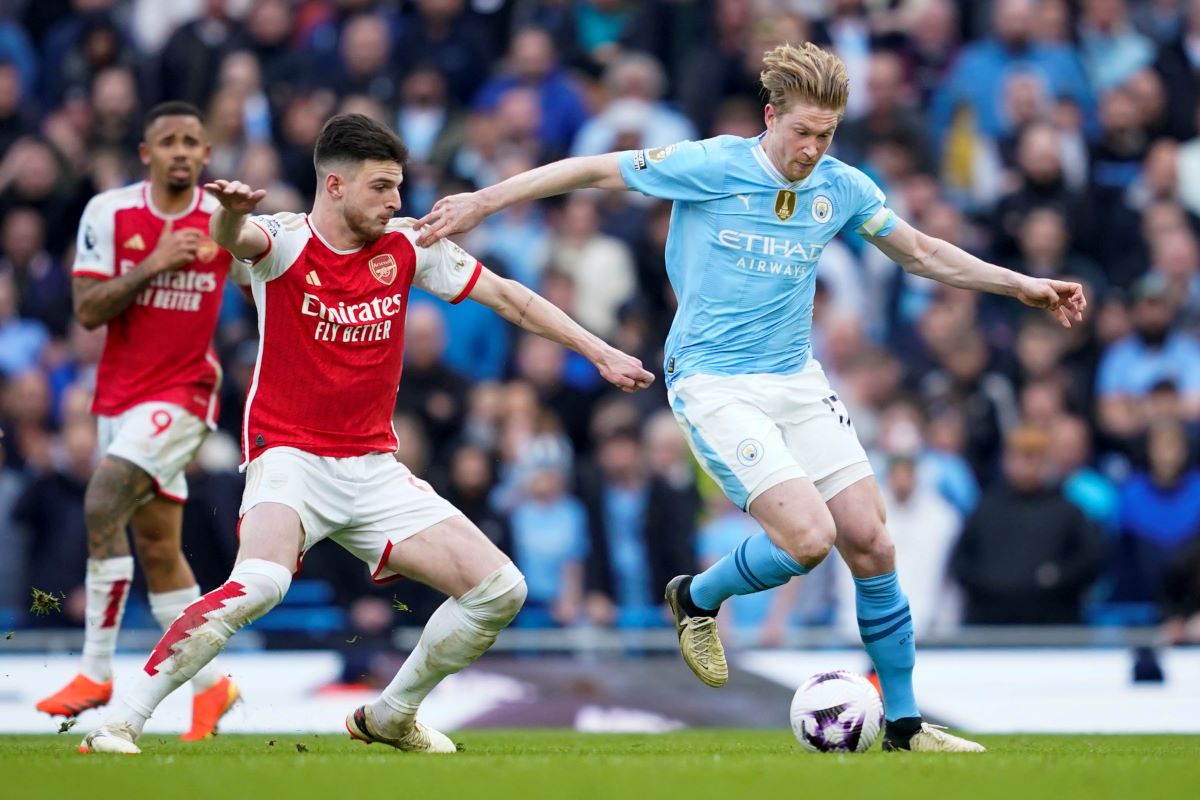 Manchester City's Kevin De Bruyne, right, duels for the ball with Arsenal's Declan Rice during the English Premier League soccer match between Manchester City and Arsenal at the Etihad stadium in Manchester, England, Sunday, March 31, 2024. (AP Photo/Dave Thompson)