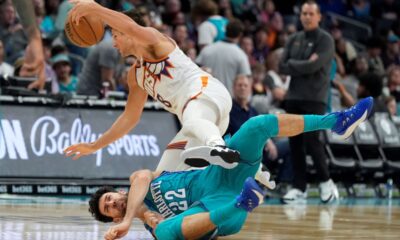Phoenix Suns guard Grayson Allen, top, and Charlotte Hornets guard Vasa Micic collide during the second half of an NBA basketball game on Friday, March 15, 2024, in Charlotte, N.C. (AP Photo/Chris Carlson)
