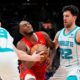 Toronto Raptors guard Immanuel Quickley, center, moves between Charlotte Hornets forward Davis Bertans (9) and Hornets' Vasilije Micić (22) during the second half of an NBA basketball game in Toronto on Sunday, March 3, 2024. (Frank Gunn/The Canadian Press via AP)