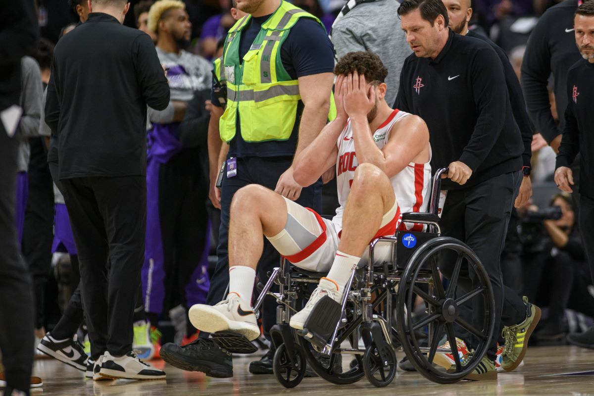 Houston Rockets center Alperen Sengun is wheeled from the arena in a wheel chair during the second half of an NBA basketball game against the Sacramento Kings in Sacramento, Calif., Sunday, March 10, 2024. (AP Photo/Randall Benton)