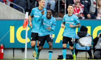 Leverkusen's Jeremie Frimpong, center, celebrates after scoring the opening goal during the Bundesliga soccer match between 1. FC Cologne and Bayer 04 Leverkusen in Cologne, Germany, Sunday, March 3, 2024. (Rolf Vennenbernd/dpa via AP)