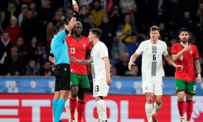 Referee Irfan Peljto shows a yellow card to Slovenia's Erik Janza, center, during the international friendly soccer match between Slovenia and Portugal at the Stozice stadium in Ljubljana, Slovenia, Tuesday, March 26, 2024. (AP Photo/Darko Bandic)