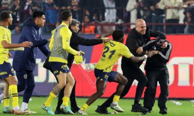 A Trabzonspor supporter, right, confronts Fenerbahce's players during clashes at the end of Turkish Super Lig soccer match between Trabzonspor and Fenerbahce at the Senol Gunes stadium in Trabzon, Turkey, Sunday, March 17, 2024. Clashes erupted between Trabzonspor fans and Fenerbahce players after local supporters stormed in the pitch at the end of the Turkish Super Lig match. (Huseyin Yavuz/Dia Images via AP)