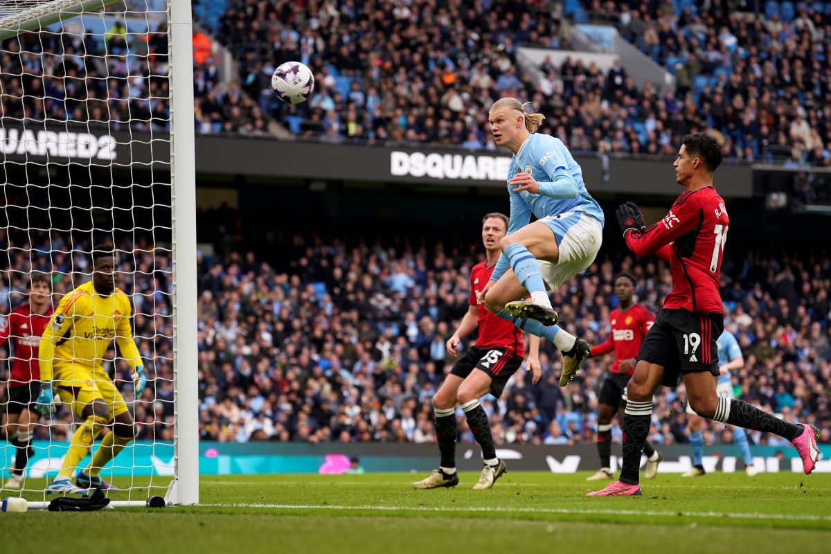Manchester City's Erling Haaland, centre tries to score during an English Premier League soccer match between Manchester City and Manchester United at the Etihad Stadium in Manchester, England, Sunday, March 3, 2024. (AP Photo/Dave Thompson)