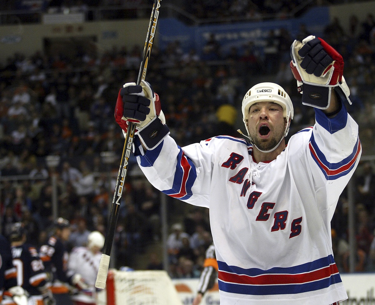 FILE - New York Rangers' Chris Simon celebrates his second-period goal against the New York Islanders, Thursday, Feb. 26, 2004, at Nassau Coliseum in Uniondale, N.Y. Former NHL enforcer Chris Simon has died. He was 52. Simon died Monday night, March 18, 2024, according to a spokesperson for the NHL Players' Association. (AP Photo/Ed Betz, File)