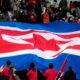 Supporters of North Korean team puts big North Korean flag prior to the FIFA World Cup 2026 and AFC Asian Cup 2027 preliminary joint qualification round 2 match between Japan and North Korea at the National Stadium at the National Stadium Thursday, March 21, 2024, in Tokyo. (AP Photo/Eugene Hoshiko)