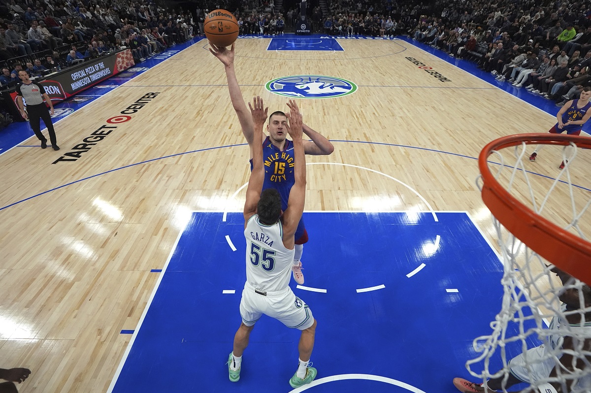 Denver Nuggets center Nikola Jokic (15) shoots over Minnesota Timberwolves center Luka Garza (55) during the first half of an NBA basketball game, Tuesday, March 19, 2024, in Minneapolis. (AP Photo/Abbie Parr)