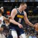 Denver Nuggets center Nikola Jokic, right, fields a pass as Cleveland Cavaliers center Jarrett Allen engages in the second half of an NBA basketball game, Sunday, March 31, 2024, in Denver. (AP Photo/David Zalubowski)