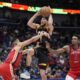 Phoenix Suns guard Devin Booker (1) goes to the basket between New Orleans Pelicans guard CJ McCollum (3) and forward Herbert Jones (5) in the second half of an NBA basketball game in New Orleans, Monday, April 1, 2024. The Suns won 124-111. (AP Photo/Gerald Herbert)