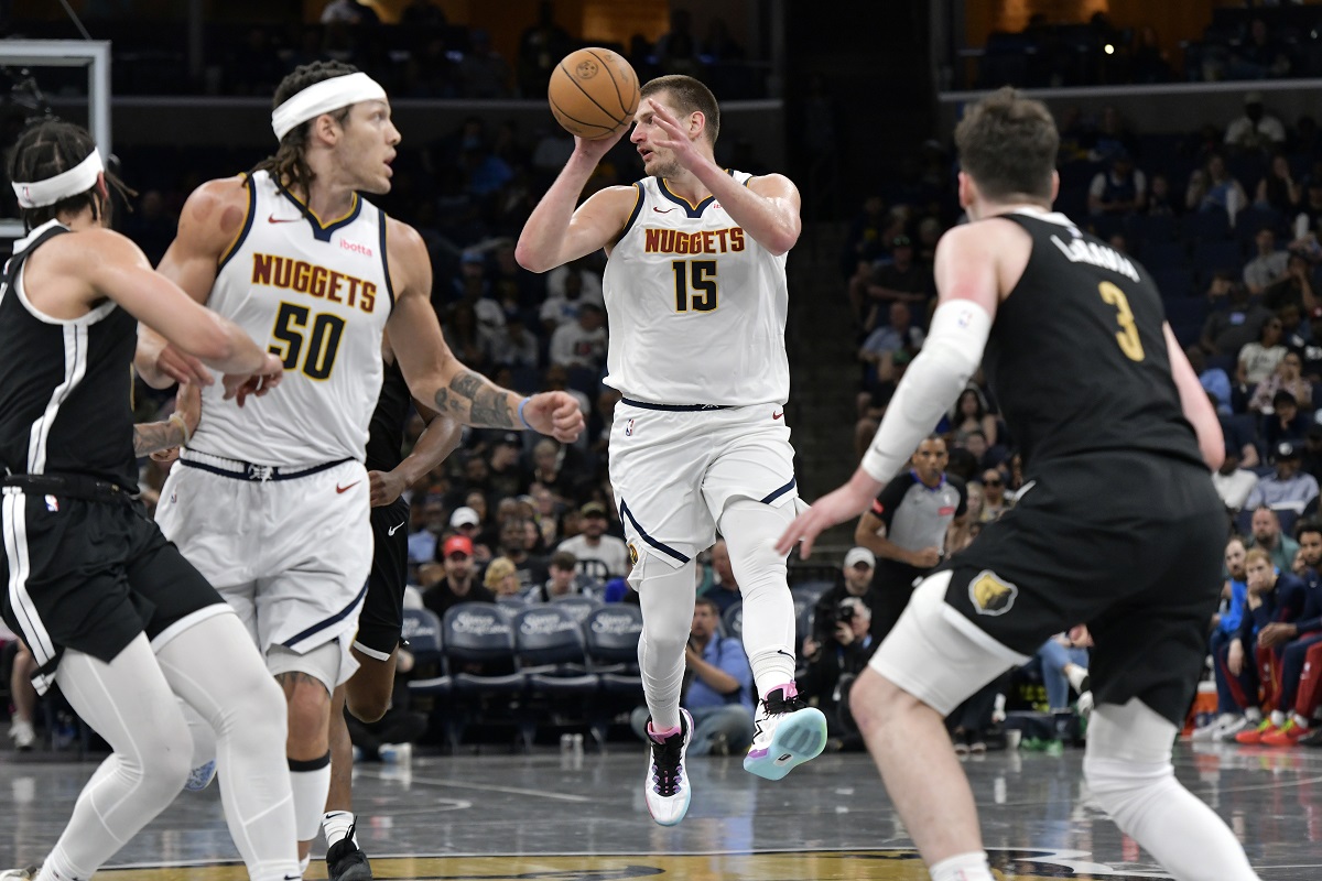 Denver Nuggets center Nikola Jokic (15) handles the ball in the second half of an NBA basketball game against the Memphis Grizzlies Sunday, April 14, 2024, in Memphis, Tenn. (AP Photo/Brandon Dill)