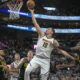 Denver Nuggets center Nikola Jokic (15) goes to the basket as Utah Jazz forward Taylor Hendricks, right, defends during the first half of an NBA basketball game Tuesday, April 9, 2024, in Salt Lake City. (AP Photo/Rick Bowmer)