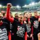 Kaiserslautern's players wear T-shirts with the slogan "Ajo! Lautre is schun widder do!" and celebrate after the final whistle at the German Soccer Cup semifinal soccer match between 1. FC Saarbrucken and 1. FC Kaiserslautern at Ludwigspark Stadium in Saarbrucken, Germany, Tuesday, April 2, 2024. (Uwe Anspach/dpa via AP)