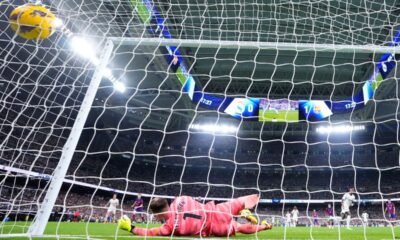 Barcelona's goalkeeper Marc-Andre ter Stegen fails to save the ball as Real Madrid's Vinicius Junior, right, celebrates after scoring his side's opening goal during the Spanish La Liga soccer match between Real Madrid and Barcelona at the Santiago Bernabeu stadium in Madrid, Spain, Sunday, April 21, 2024. (AP Photo/Manu Fernandez)