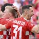 Mainz's scorer Jonathan Burkhardt, center, celebrate their side's first goal during the German Bundesliga soccer match between FSV Mainz 05 and TSG 1899 Hoffenheim in Mainz, Germany, Saturday, April 13, 2024. (Torsten Silz/dpa via AP)