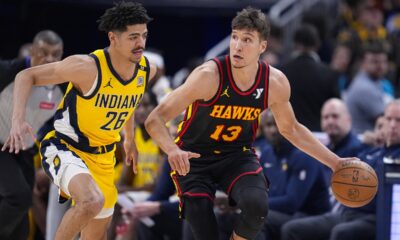 Indiana Pacers guard Ben Sheppard (26) defends Atlanta Hawks guard Bogdan Bogdanovic (13) during the first half of an NBA basketball game in Indianapolis, Sunday, April 14, 2024. (AP Photo/Michael Conroy)
