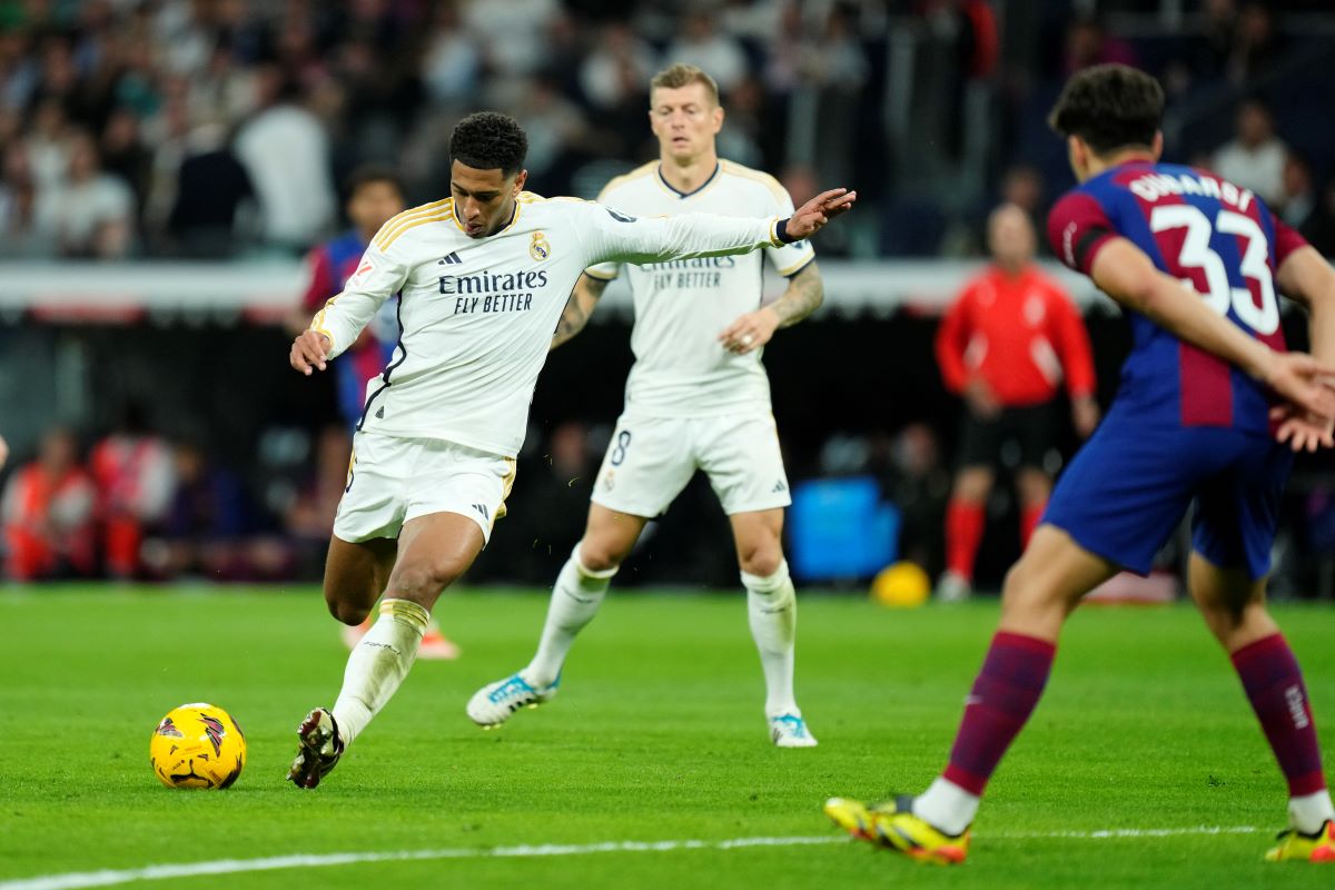Real Madrid's Jude Bellingham shoots the ball during the Spanish La Liga soccer match between Real Madrid and Barcelona at the Santiago Bernabeu stadium in Madrid, Spain, Sunday, April 21, 2024. (AP Photo/Jose Breton)