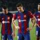 From left, Barcelona's Ferran Torres, Barcelona's Robert Lewandowski, Barcelona's Inigo Martinez react at the end of the Champions League quarterfinal second leg soccer match between Barcelona and Paris Saint-Germain at the Olimpic Lluis Companys stadium in Barcelona, Spain, Tuesday, April 16, 2024. (AP Photo/Joan Monfort)