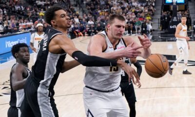 San Antonio Spurs center Victor Wembanyama, center, knocks the ball away from Denver Nuggets center Nikola Jokic (15) during the second half of an NBA basketball game in San Antonio, Friday, April 12, 2024. (AP Photo/Eric Gay)