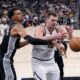 San Antonio Spurs center Victor Wembanyama, center, knocks the ball away from Denver Nuggets center Nikola Jokic (15) during the second half of an NBA basketball game in San Antonio, Friday, April 12, 2024. (AP Photo/Eric Gay)