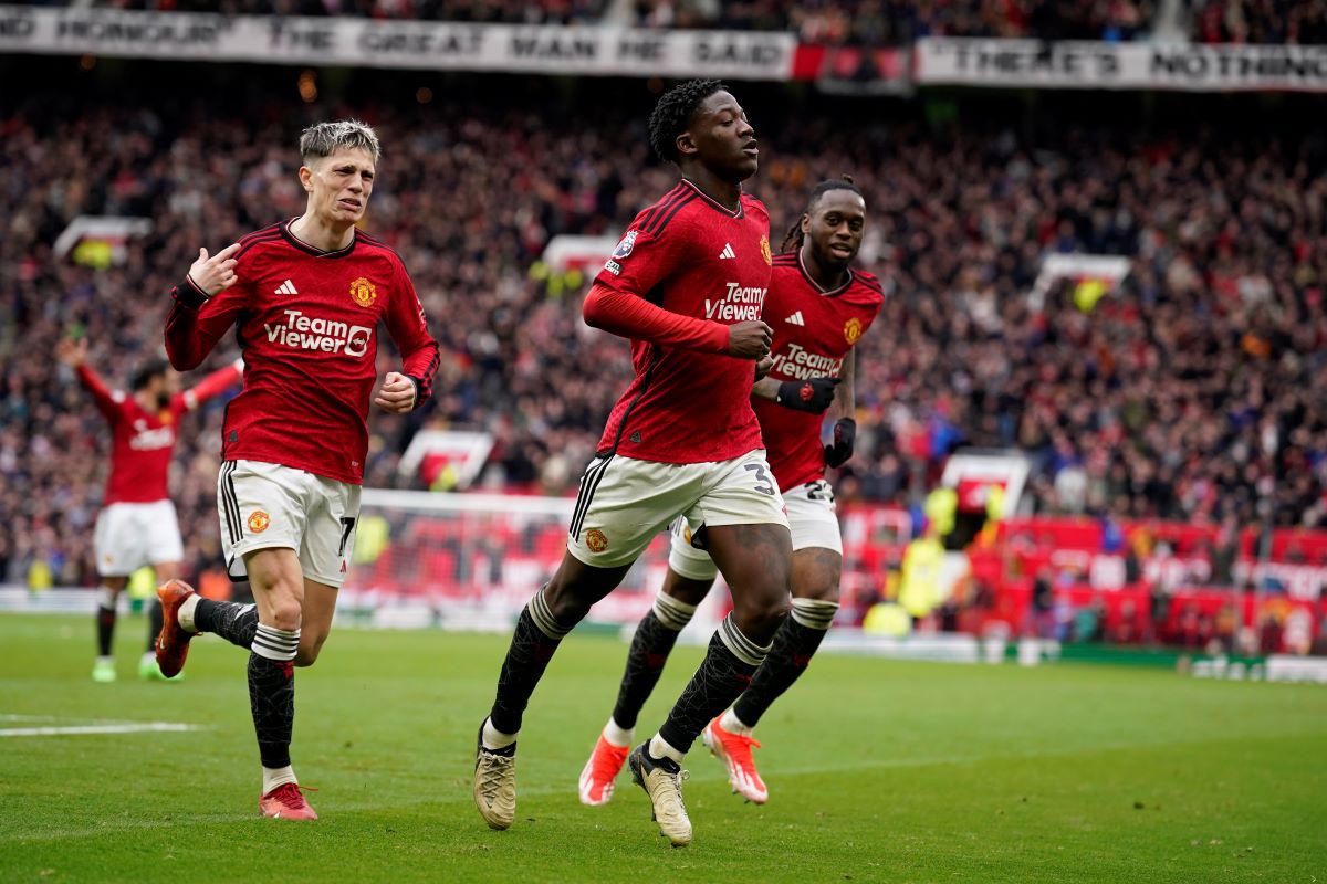 Manchester United's Kobbie Mainoo, centre, celebrates after scoring his side's second goal during the English Premier League soccer match between Manchester United and Liverpool at the Old Trafford stadium in Manchester, England, Sunday, April 7, 2024. (AP Photo/Dave Thompson)