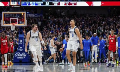This handout photo provided by the Dallas Mavericks shows Dallas Mavericks guard Dante Exum (0) celebrating his last second three pointer with teammate Luka Doncic (77) as Houston Rockets defenders Reggie Bullock Jr. (25), Jabari Smith Jr. (10) and Jalen Green (4) look on at the end of the fourth quarter of an NBA basketball game Sunday, April 7, 2024 in Dallas. (Dallas Mavericks via AP)