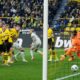 Leverkusen's Josip Stanisic, up, scores for his team in the last minute against Dortmund's goalkeeper Gregor Kobel, right, during the German Bundesliga soccer match between Borussia Dortmund and Bayer Leverkusen in Dortmund, Germany, Sunday, April 21, 2024. The match ended 1-1, Leverkusen is unbeaten since 45 matches. (AP Photo/Martin Meissner)