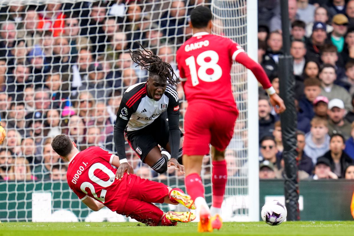 Fulham's Alex Iwobi, center top, duels for the ball with Liverpool's Diogo Jota during the English Premier League soccer match between Fulham and Liverpool at Craven Cottage stadium in London, Sunday, April 21, 2024. (AP Photo/Kirsty Wigglesworth)