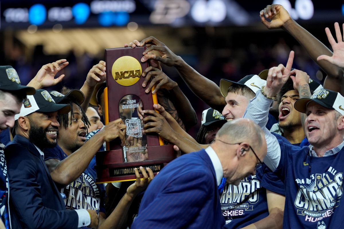 UConn celebrates with the trophy after their win against Purdue in the NCAA college Final Four championship basketball game, Monday, April 8, 2024, in Glendale, Ariz. (AP Photo/David J. Phillip)