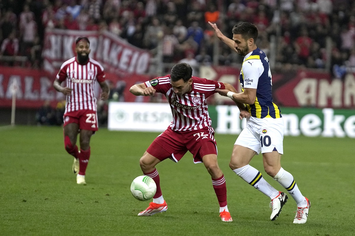 Olympiacos' Santiago Hezze, left, and Fenerbahce's Dusan Tadic fight for the ball during the Europa Conference League quarter final first leg soccer match between Olympiacos and Fenerbahce at the Georgios Karaiskakis stadium, Piraeus port near Athens, Greece, Thursday, April 11, 2024. (AP Photo/Thanassis Stavrakis)
