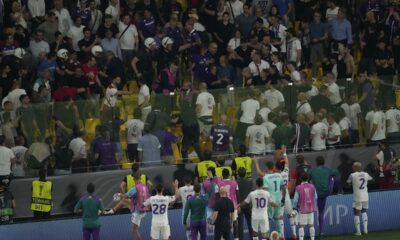 Fiorentina players try to deescalated during their supporters clashes with police at the half time during the Conference League final soccer match between Olympiacos FC and ACF Fiorentina at OPAP Arena in Athens, Greece, Wednesday, May 29, 2024. (AP Photo/Petros Karadjias)