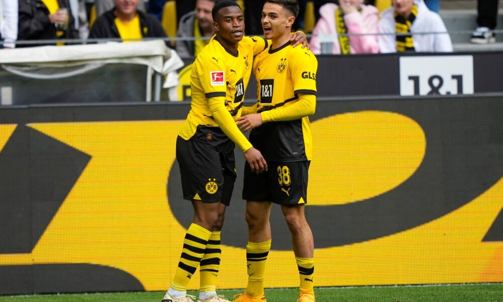 Dortmund's Youssoufa Moukoko, leftt, celebrates with his teammate Watjen Kjell-Arik after he scored his side's first goal during the German Bundesliga soccer match between Borussia Dortmund and Augsburg, in Dortmund, Saturday, May 4, 2024. (AP Photo/Martin Meissner)