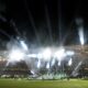 Volunteers hold banners on the pitch before the Conference League final soccer match between Olympiacos FC and ACF Fiorentina at OPAP Arena in Athens, Greece, Wednesday, May 29, 2024. (AP Photo/Petros Giannakouris)