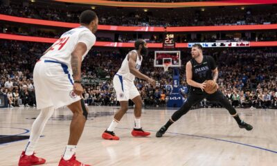 Dallas Mavericks guard Luka Doncic (77) steps back to take a shot in front of Los Angeles Clippers guard James Harden, center, as guard Norman Powell (24) looks on during the second half of an NBA basketball first-round playoff series Friday, May 3, 2024, in Dallas. (AP Photo/Jeffrey McWhorter)