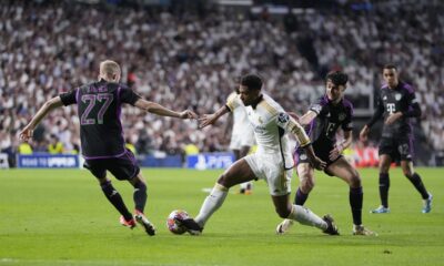 Real Madrid's Jude Bellingham, center, is challenged by Bayern's Konrad Laimer, left, and Bayern's Aleksandar Pavlovic during the Champions League semifinal second leg soccer match between Real Madrid and Bayern Munich at the Santiago Bernabeu stadium in Madrid, Spain, Wednesday, May 8, 2024. (AP Photo/Manu Fernandez)