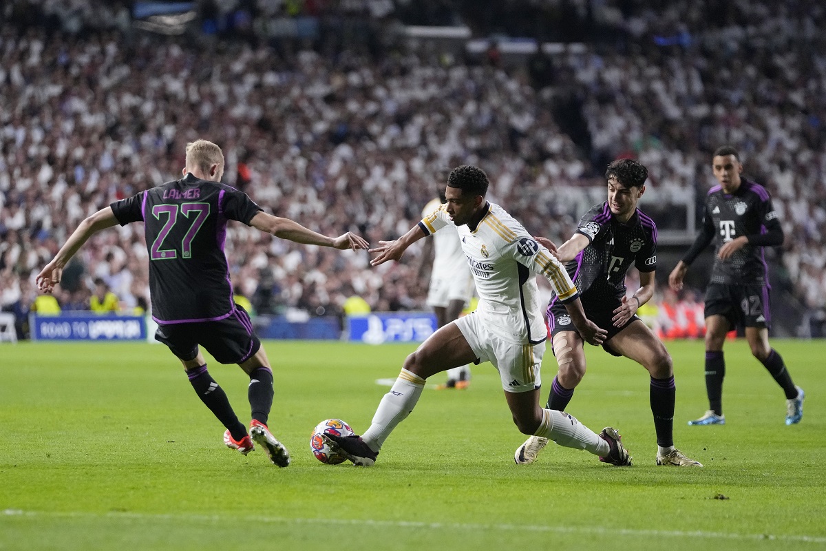 Real Madrid's Jude Bellingham, center, is challenged by Bayern's Konrad Laimer, left, and Bayern's Aleksandar Pavlovic during the Champions League semifinal second leg soccer match between Real Madrid and Bayern Munich at the Santiago Bernabeu stadium in Madrid, Spain, Wednesday, May 8, 2024. (AP Photo/Manu Fernandez)