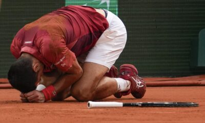 Two ball kids come to the aid of Serbia's Novak Djokovic after he slipped and fell during his fourth round match of the French Open tennis tournament against Argentina's Francisco Cerundolo at the Roland Garros stadium in Paris, Monday, June 3, 2024. (AP Photo/Thibault Camus)
