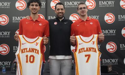 Atlanta Hawks' Zaccharie Risacher, left, General Manager Landry Fields, center, and Atlanta Hawks' Nikola Djurišić hold up their jerseys after an NBA basketball news conference, Friday, June 28, 2024, in Atlanta. Risacher was selected as the first overall pick by the Atlanta Hawks in the first round of the NBA basketball draft. (AP Photo/Brynn Anderson)