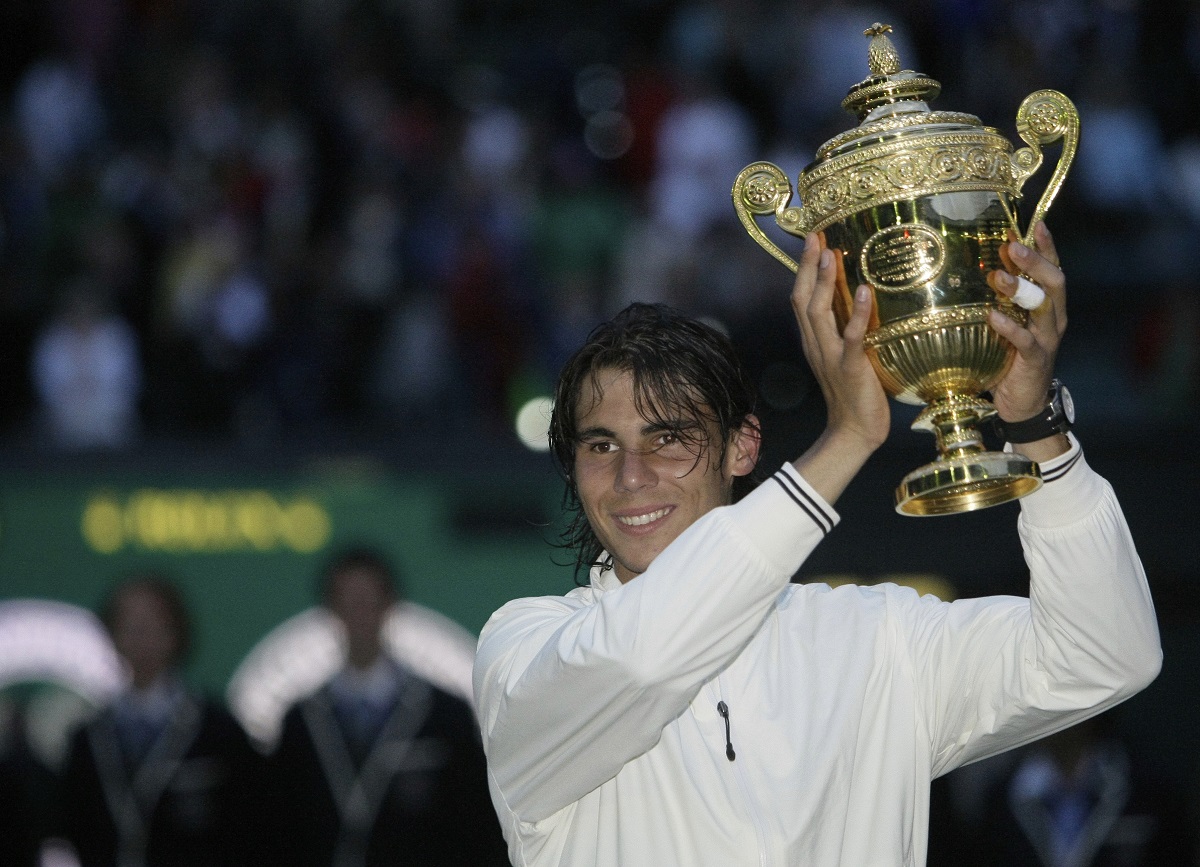 FILE - Spain's Rafael Nadal holds his trophy as he celebrates his defeat of Switzerland's Roger Federer in the men's singles final at Wimbledon, Sunday, July 6, 2008. Nadal is going to skip Wimbledon, as expected, and instead prepare for the Paris Olympics by entering a clay-court tournament in Bastad, Sweden. The 22-time Grand Slam champion said Thursday, June 13, 2024, he wants to just remain on clay, rather than switching over to grass for the All England Club and then needing to go back to clay.(AP Photo/Anja Niedringhaus, File)